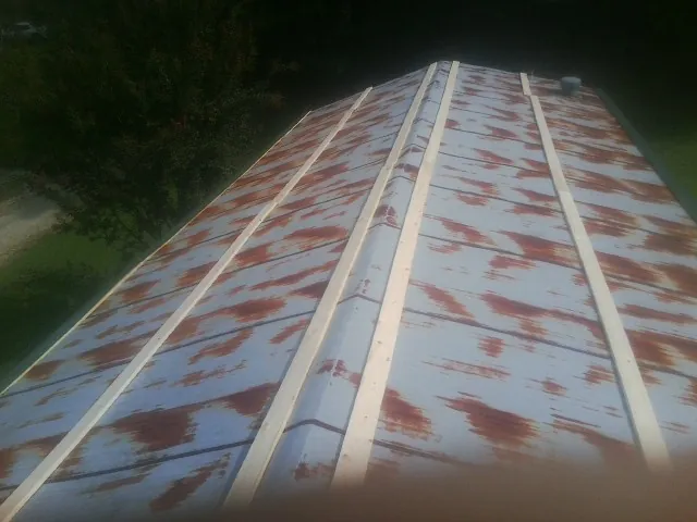 Rusted metal roof panels with new wood purlins before replacement — Storm Damage Roof Repair in Westgate by Roofing Brothers