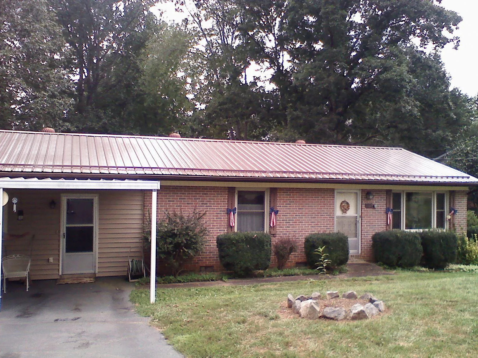Bronze metal roof and carport on a brick ranch home — Roof Repair work by our crew in Westgate